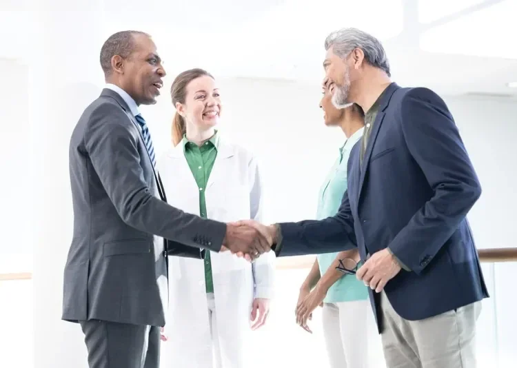 A physician, purchaser and a healthcare professional are having a conversation in a bright room in the hospital