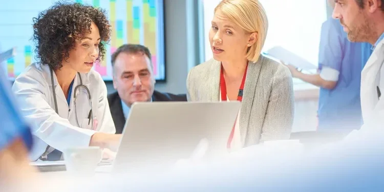 Three business people looking at a laptop