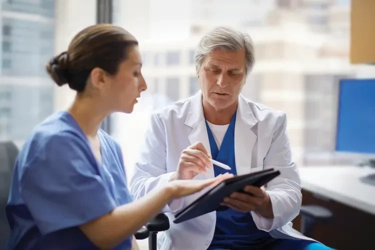 doctor showing nurse information on tablet