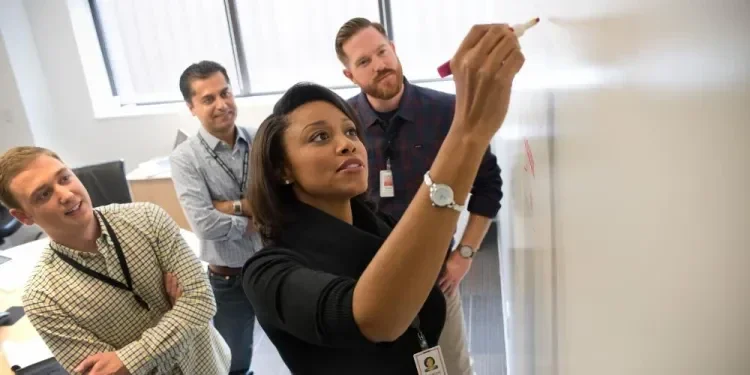 Four associates looking at a whiteboard.