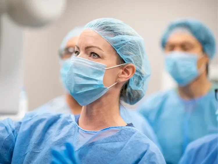 Three people in full surgical protective gear