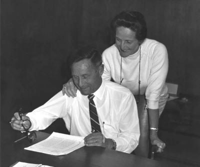 black and white photo of bill and vieve gore reviewing paperwork