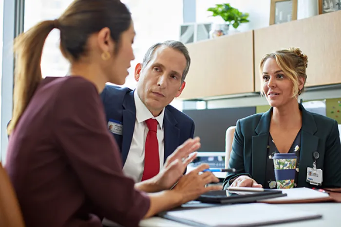 Three people discussing documents