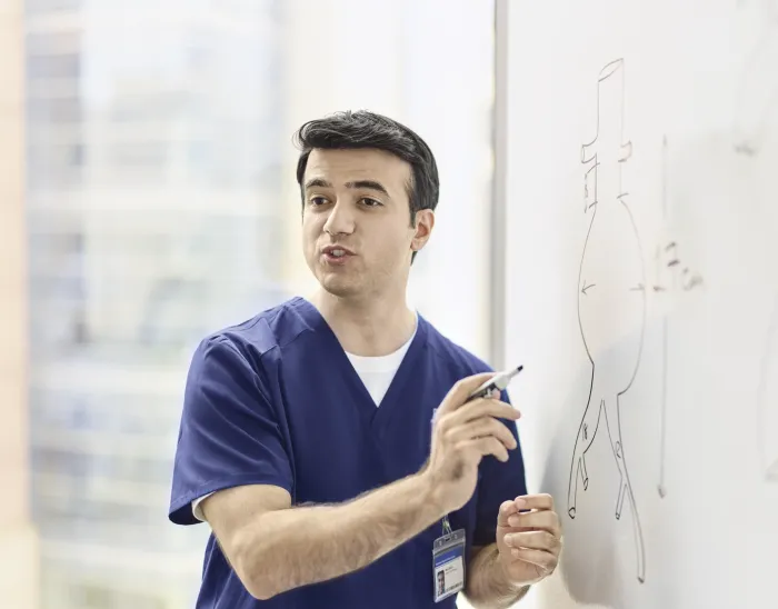 male showing something on a whiteboard mid sentence