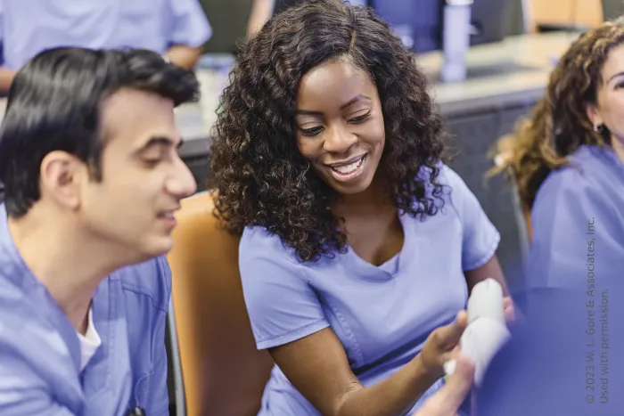two students looking at a product and smiling
