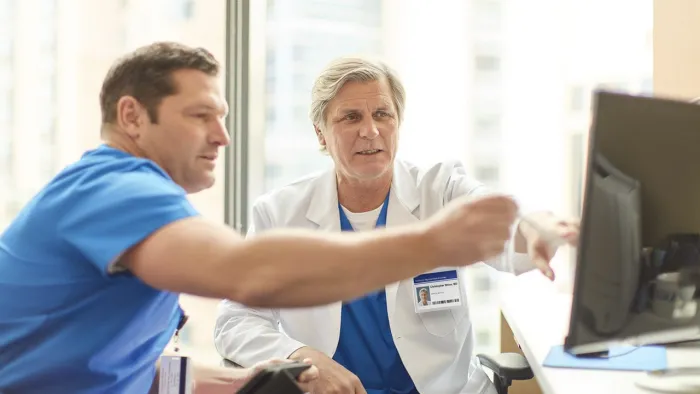 Physicians looking at computer screen and planning a case.