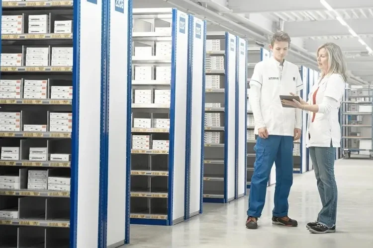 Two people having a discussion next to shelves of products